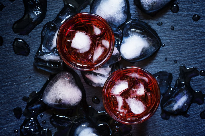 Chilled red wine bottle in an ice bucket beside a glass of red wine