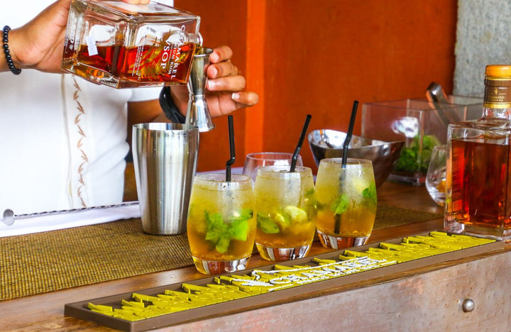 Bartender preparing a rum cocktail drink at a tropical bar