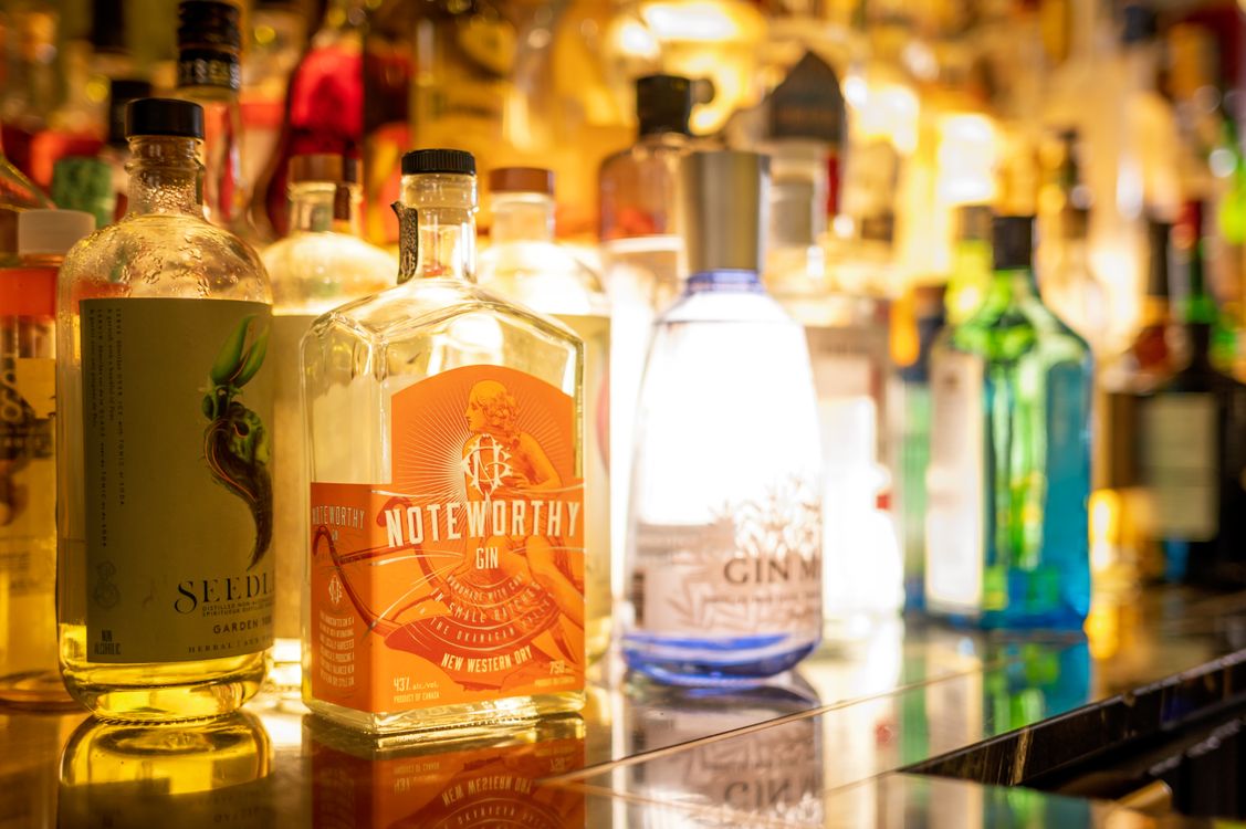 Premium backlit alcohol bottles displayed at a craft spirits bar