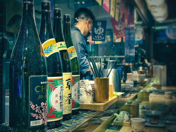 Sake and Japanese spirits bottles at an izakaya bar
