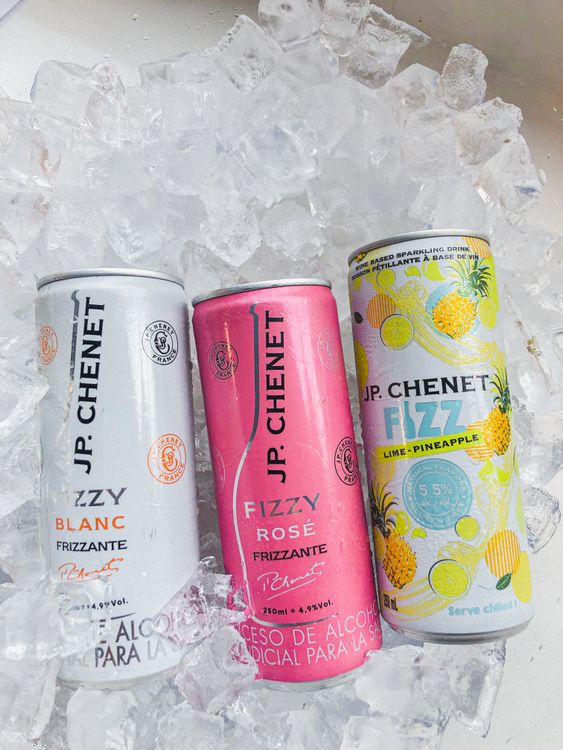 Canned cocktails chilling in ice at an outdoor summer party