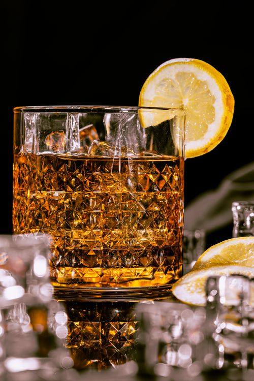 Glass of whiskey with a lemon slice, perfect for bourbon beginners