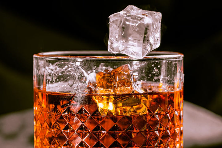 Glass of whiskey with ice cubes - allocated and rare bourbon guide