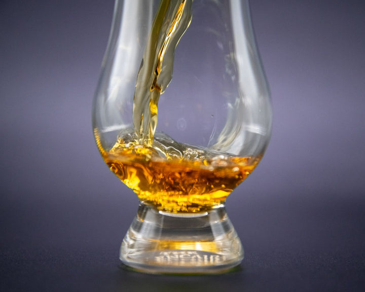 Amber whiskey poured into an elegant Glencairn glass