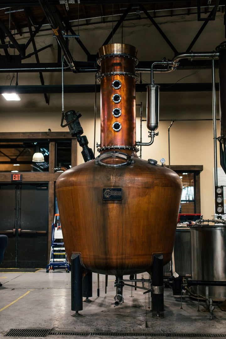 Large copper pot still inside a craft distillery