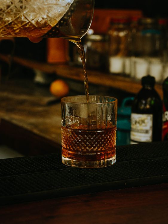 Pouring whisky into a glass for July 4th Independence Day bourbon celebration
